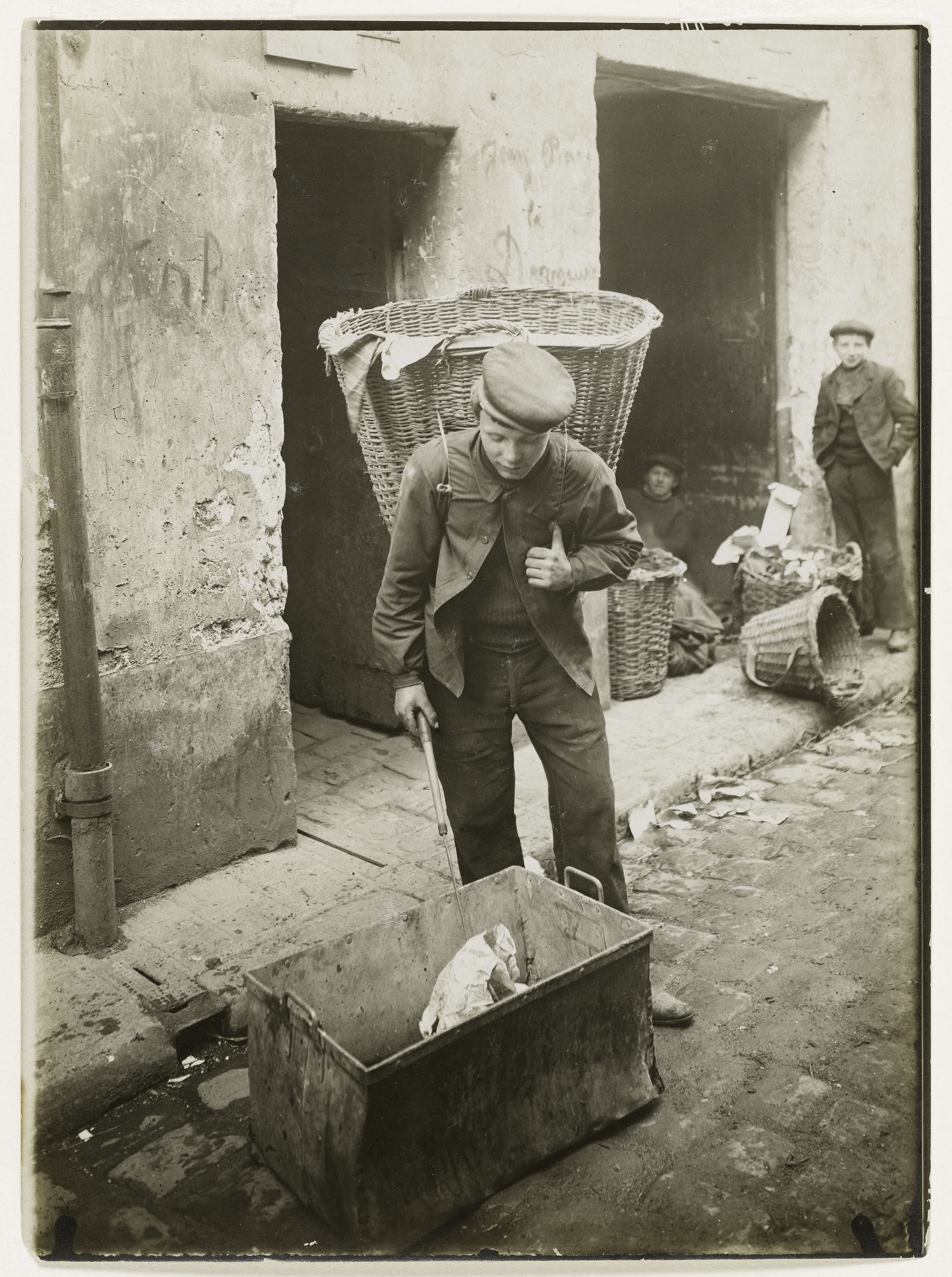 A Paris chiffonnier tipping his basket